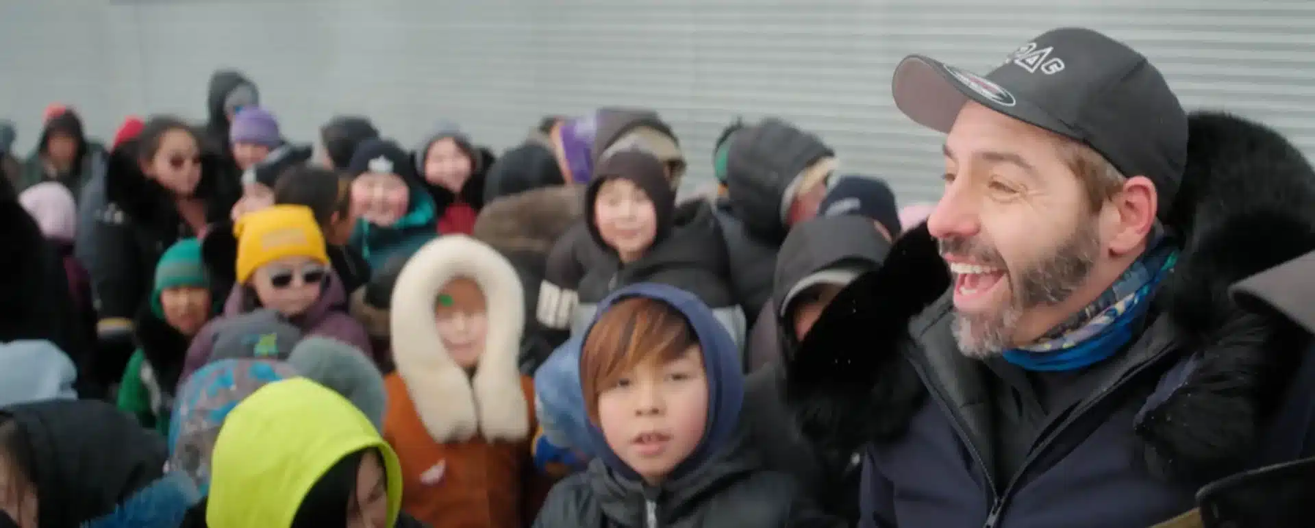 NPS officer laughing with a group of children in a Nunavik community